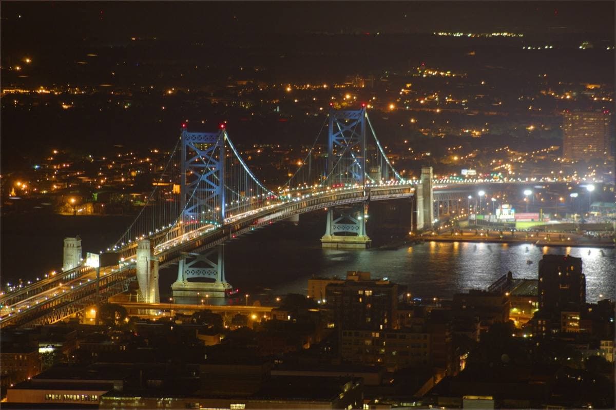 The lit suspension bridge over the Delaware River at night