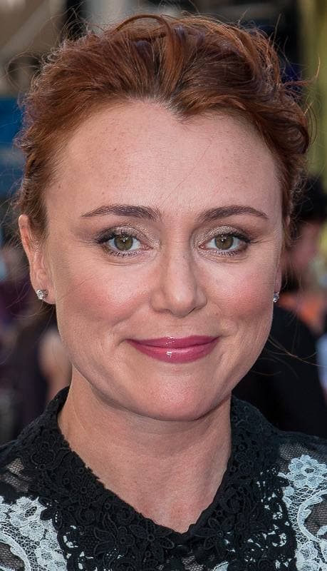 A woman with red-brown hair pinned up, smiling