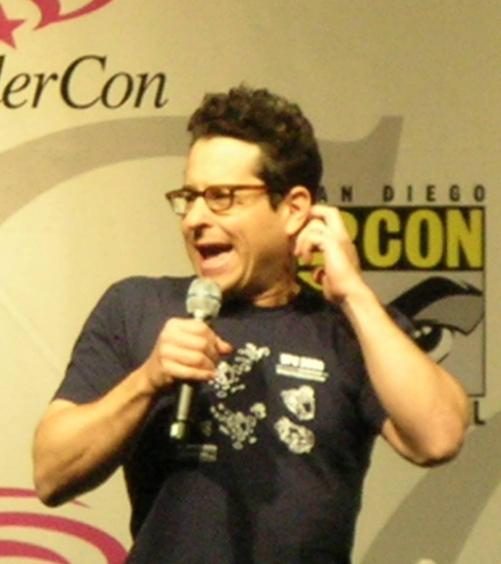 J. J. Abrams in glasses and a dark T-shirt, talking into a microphone on stage