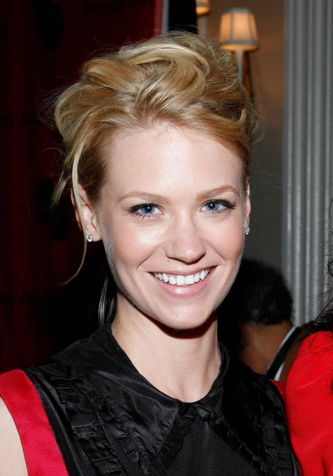 January Jones smiling, hair pinned up