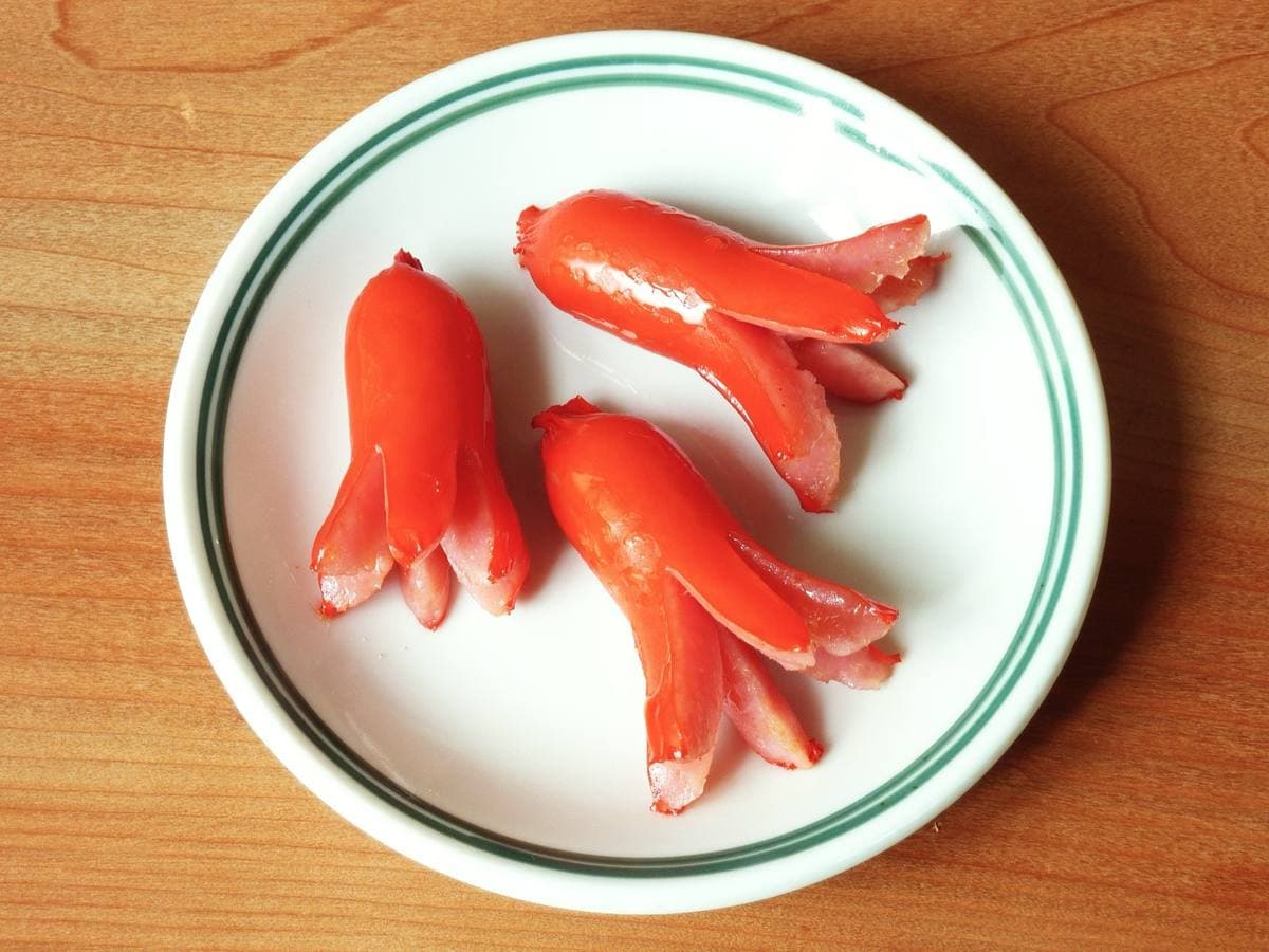 Red sausages cut into octopus shapes on a white plate