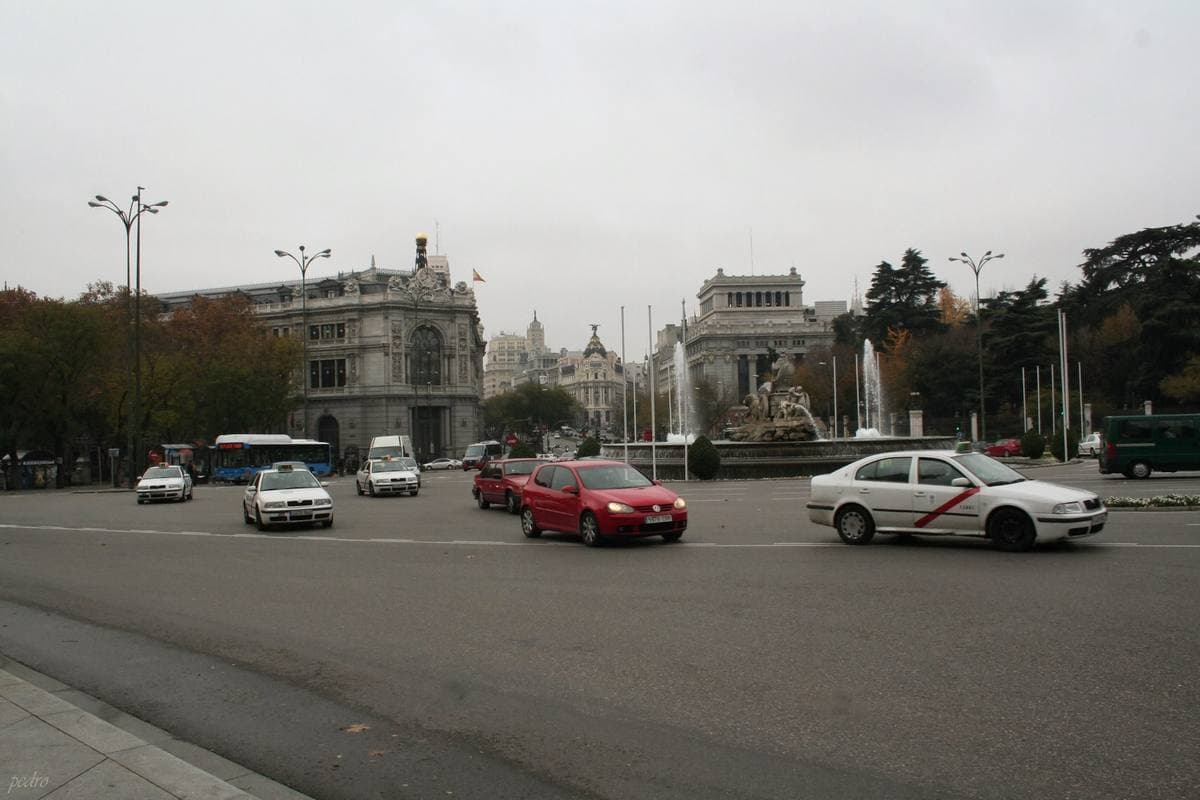 A busy roundabout with a fountain and grand stone buildings