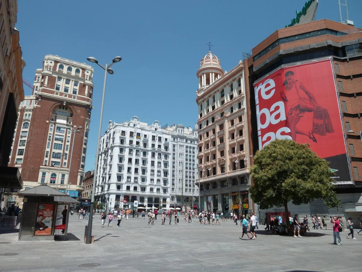 A pedestrian square ringed by cinema and department store fronts