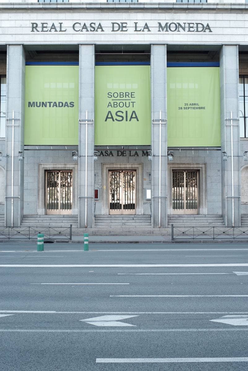 A tall modern brick building with the mint's name over its entrance