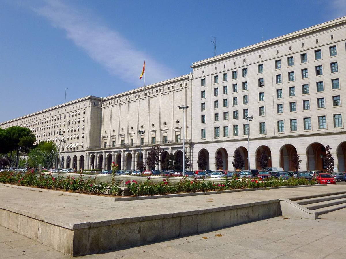 A long brick and granite government building with rows of windows