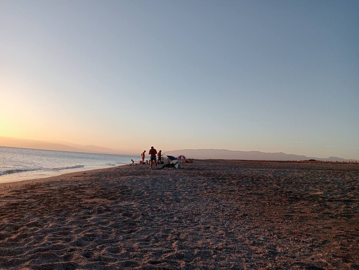 A long empty beach under a pale evening sky