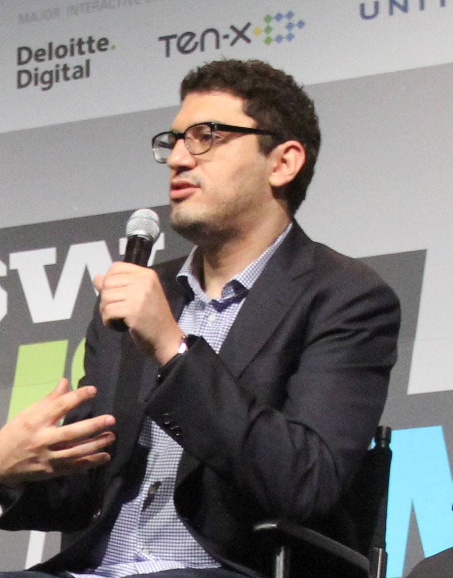 Sam Esmail in glasses, speaking into a microphone