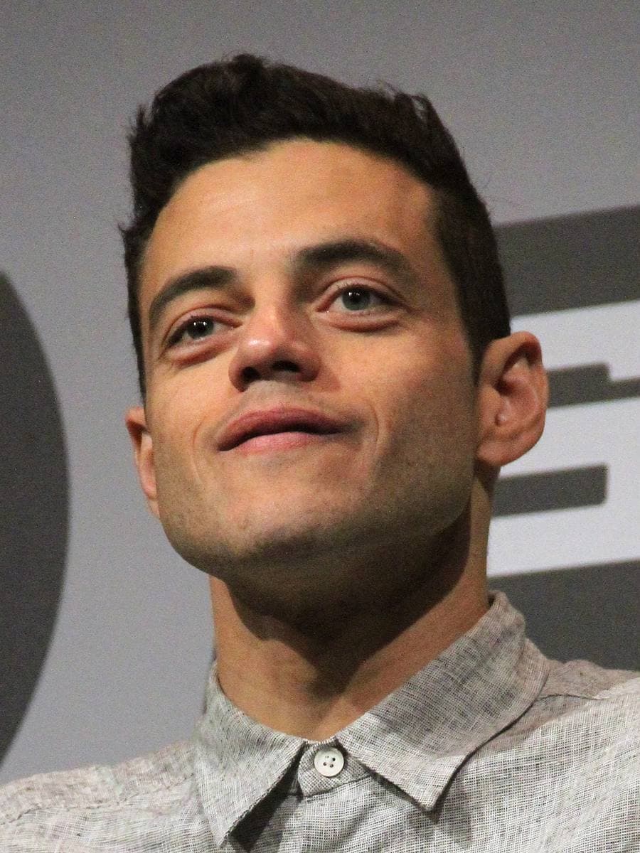 Rami Malek, short dark hair, looking up and to the side