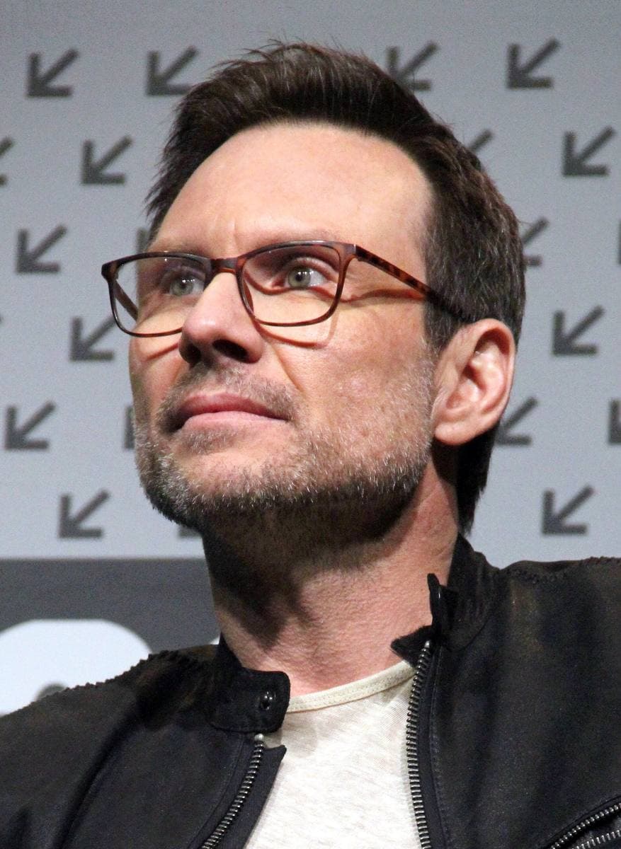 Christian Slater in glasses and a dark jacket