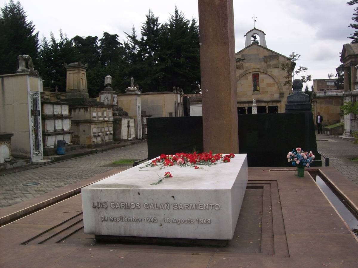 A pale stone tomb with flowers in a cemetery