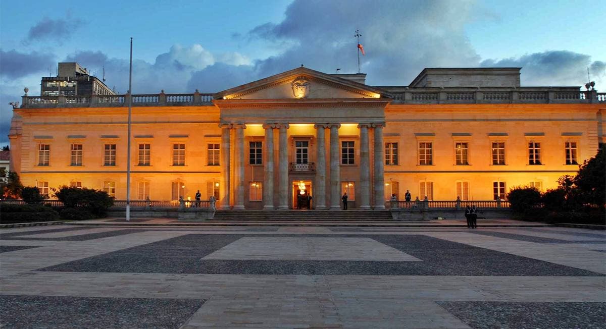 A pale neoclassical palace front behind railings
