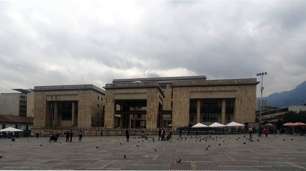 A long modern stone building with columns facing a wide square