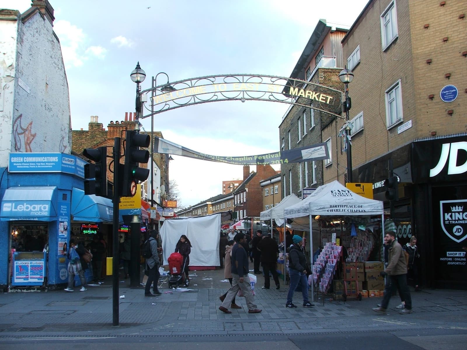 A busy market street under an arch sign reading Market