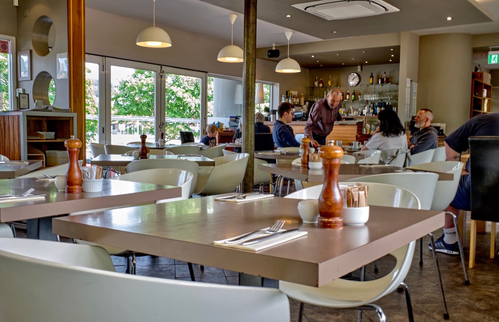 A bright café dining room with windows onto the water
