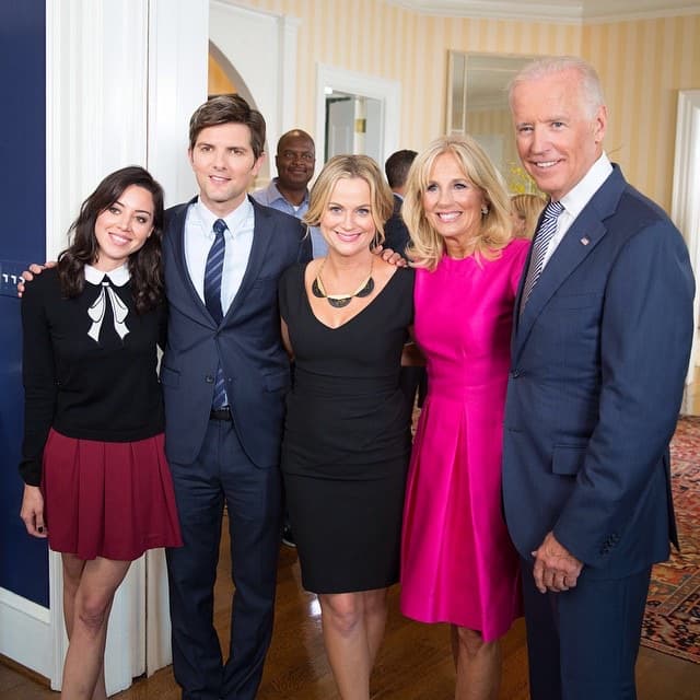 Three actors and Joe and Jill Biden standing together in a hallway, smiling