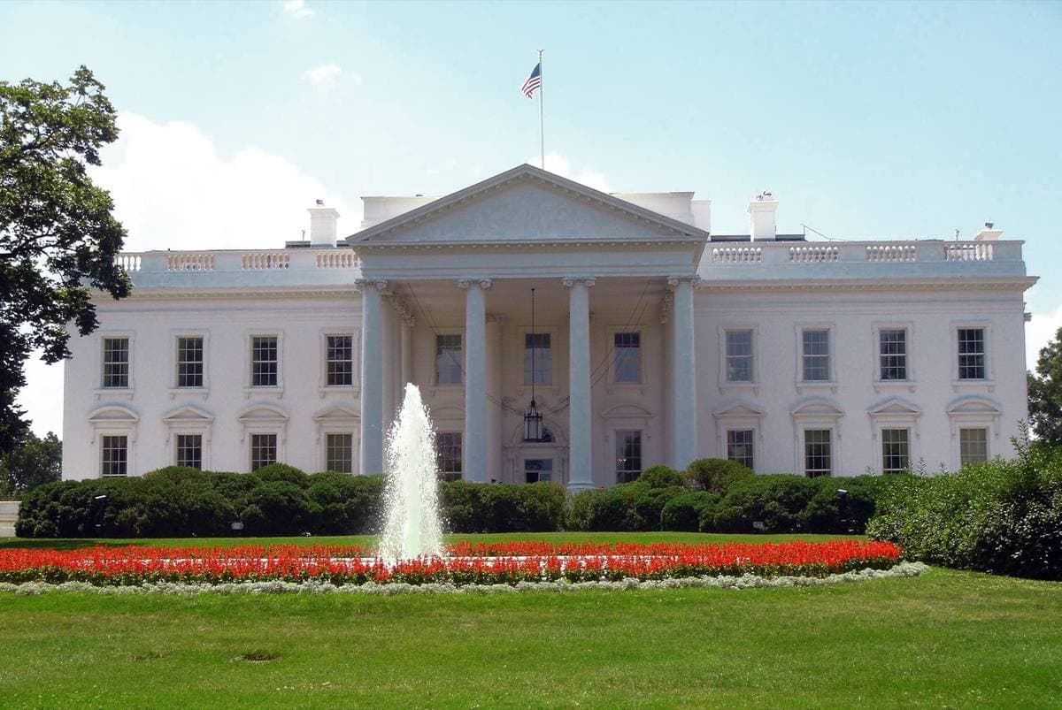 The White House north portico behind a fountain and red flower beds
