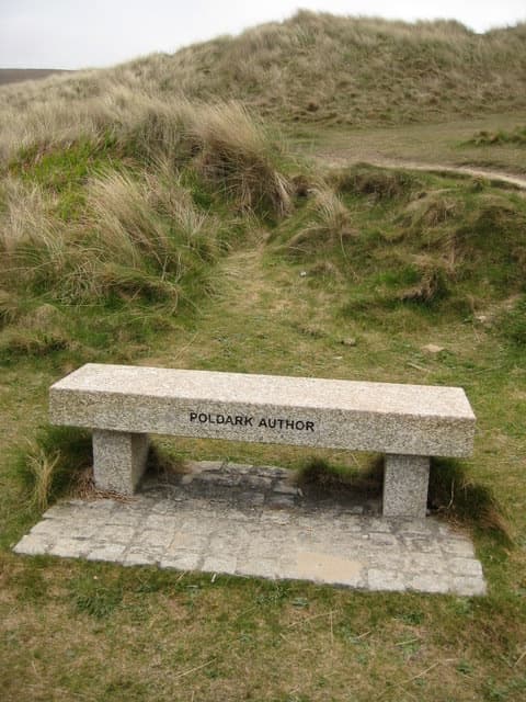 A plain stone bench set on paving in the dunes