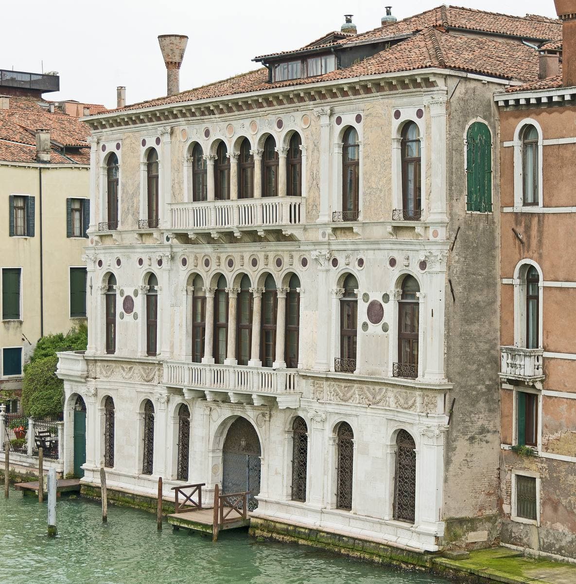 A Renaissance palazzo with marble roundels and arched windows above the Grand Canal