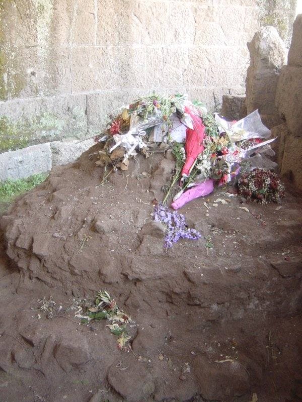 Flowers laid on a rough rounded mass of ancient concrete
