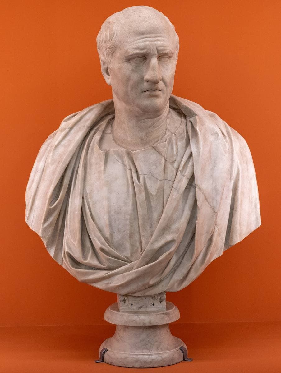A marble bust of a man in a toga with a deeply lined face