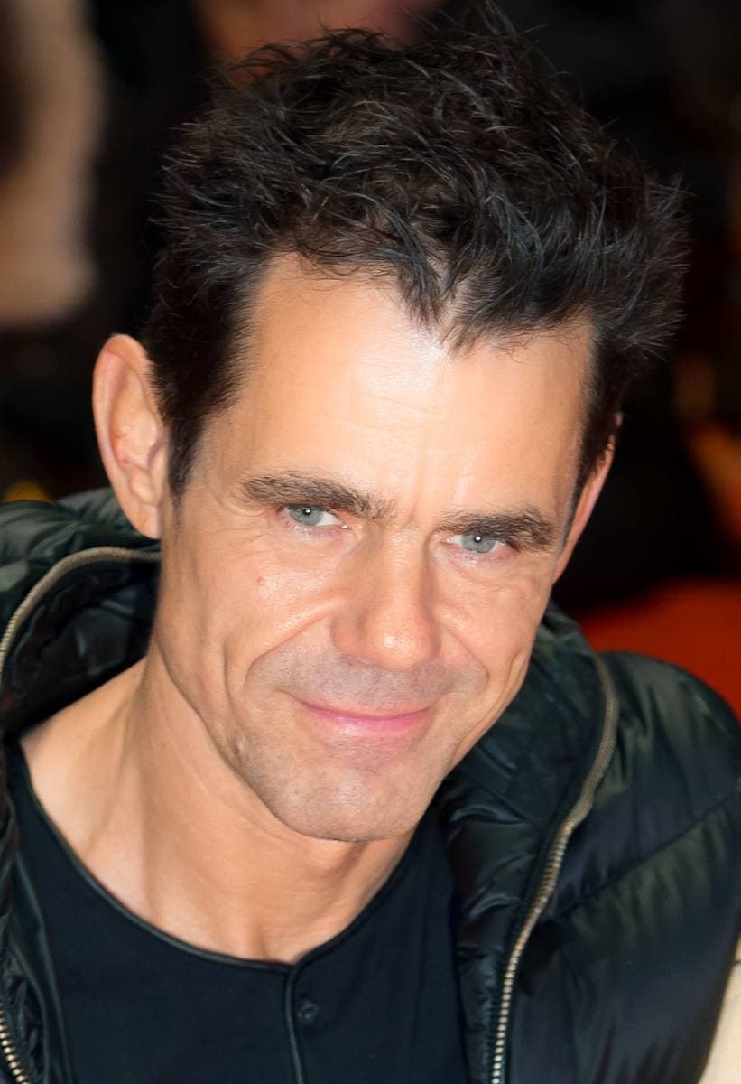 Tom Tykwer smiling, in a dark jacket