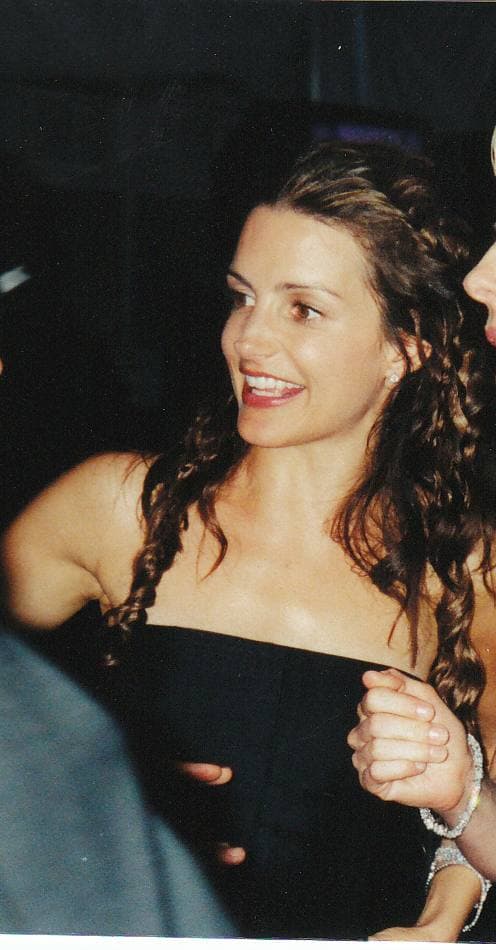 Kristin Davis, dark curls, laughing, in a black strapless top