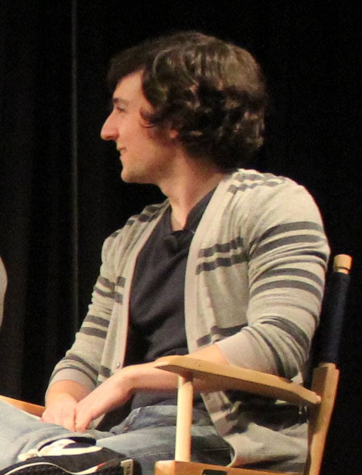 Josh Brener seated on a panel stage