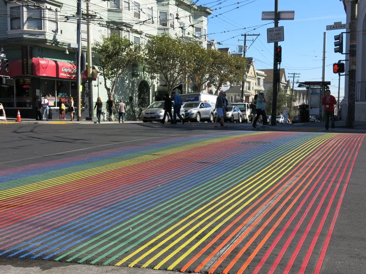 A crossing painted in rainbow stripes at a Castro street corner