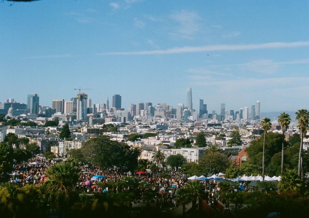 A crowded park slope with the downtown skyline beyond