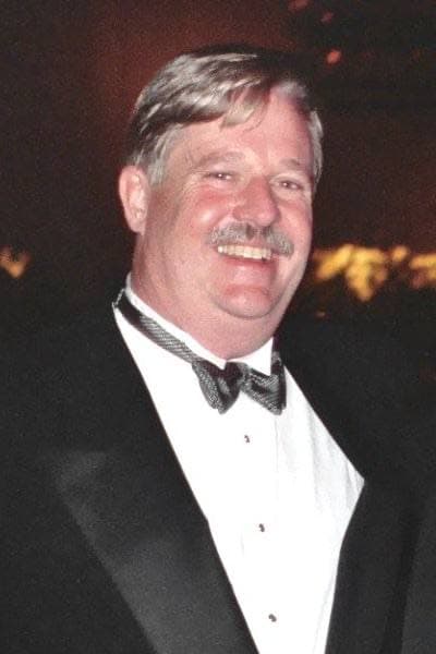 Armistead Maupin smiling in a dinner jacket and bow tie