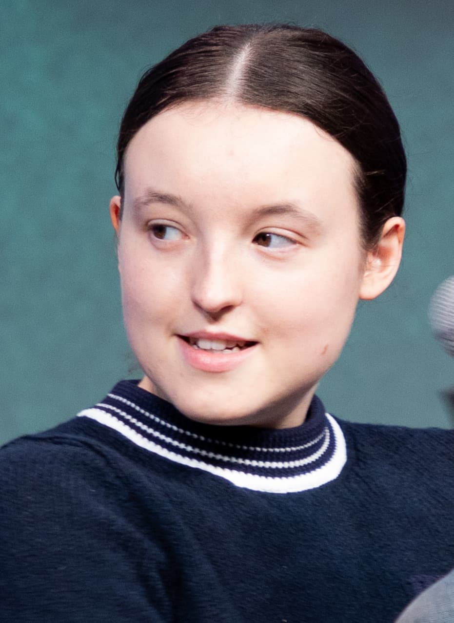 Bella Ramsey smiling and looking to one side