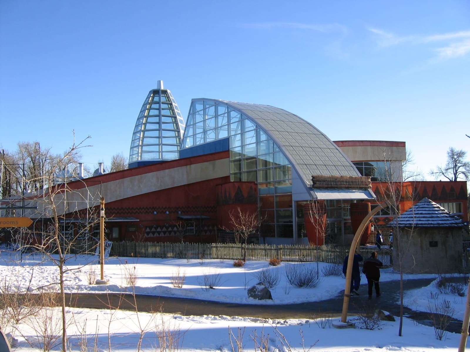 Glass-domed zoo buildings among bare trees and snow