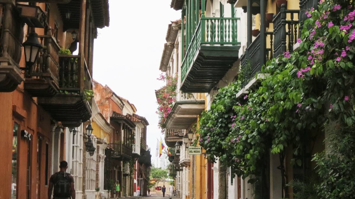 A colonial street with wooden balconies and bougainvillea