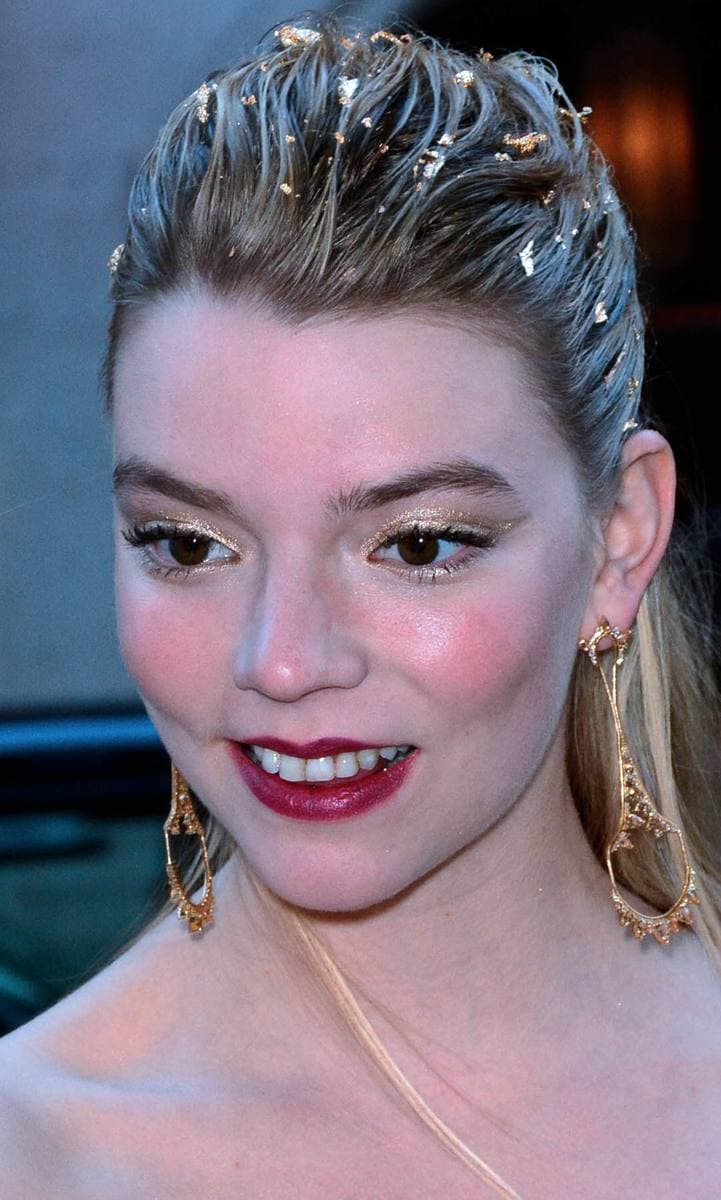 Anya Taylor-Joy with long pale hair, looking towards the camera