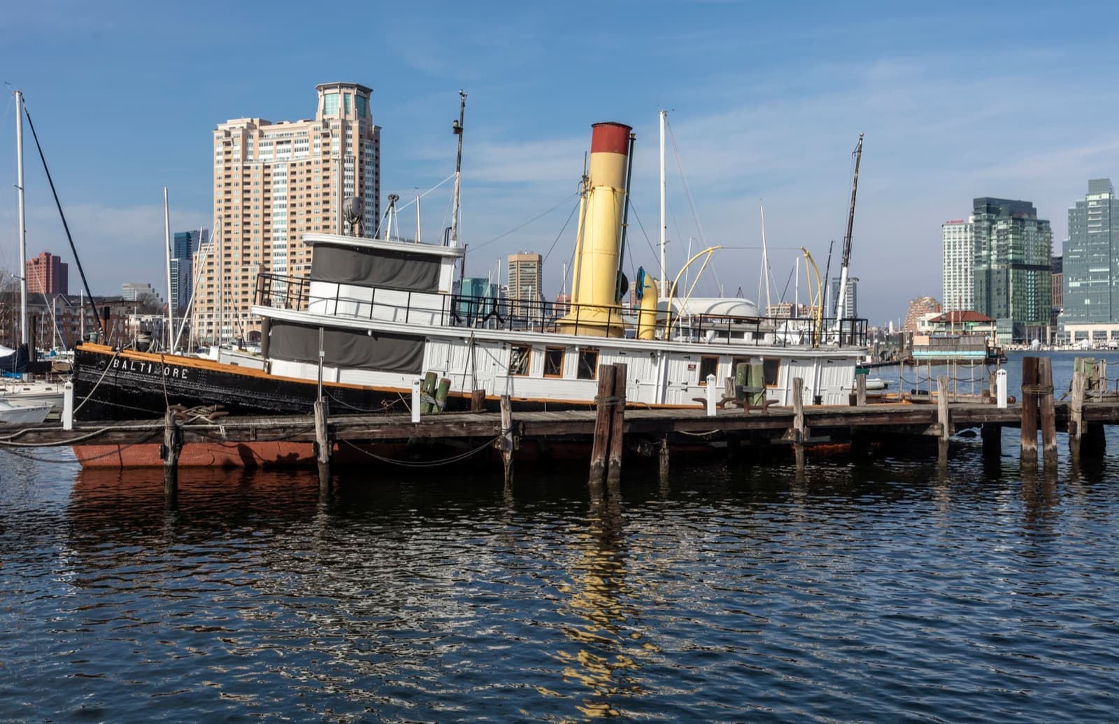 A small black-hulled steam tug moored at a museum wharf