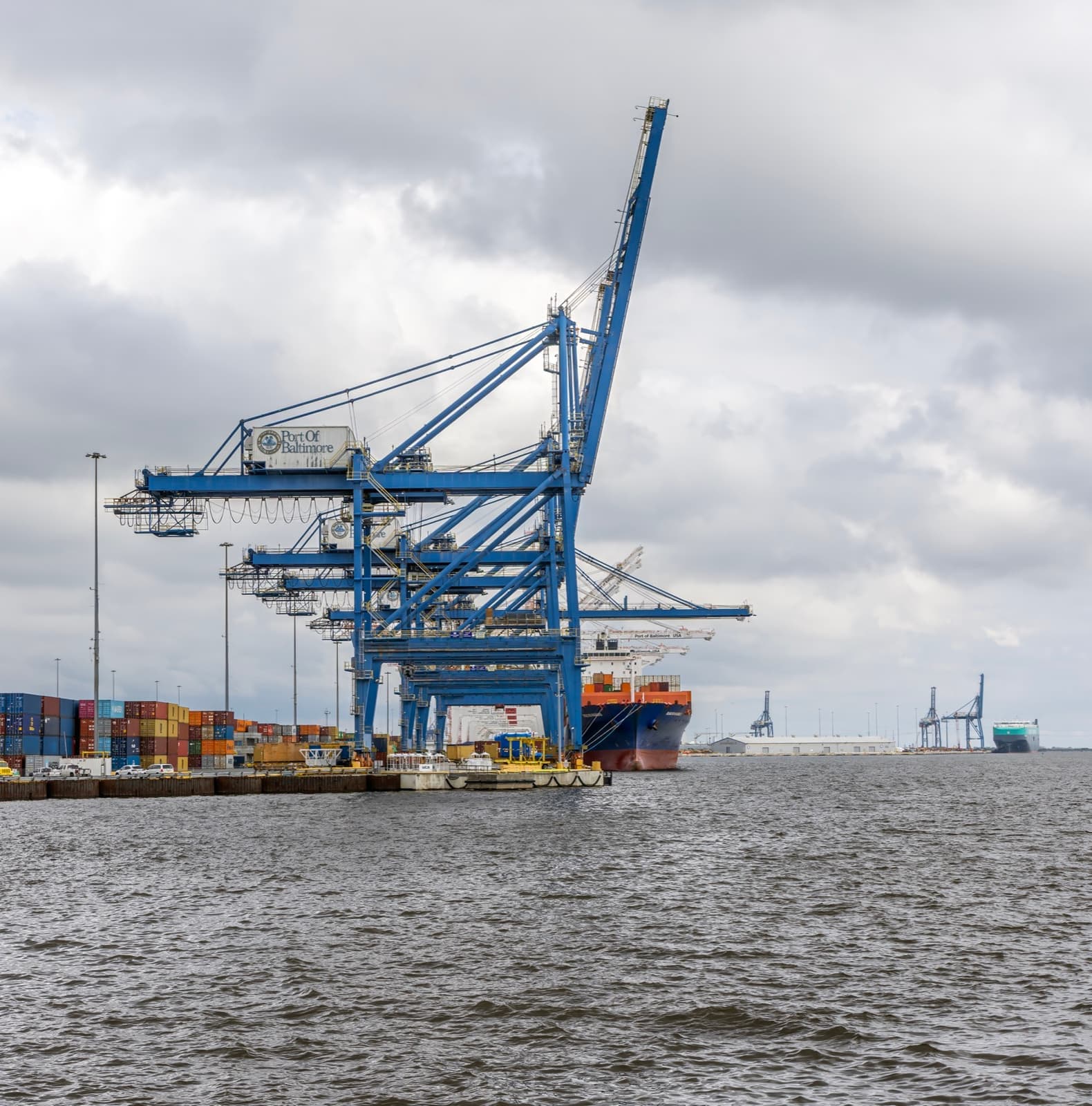 A single container crane standing over the harbour water