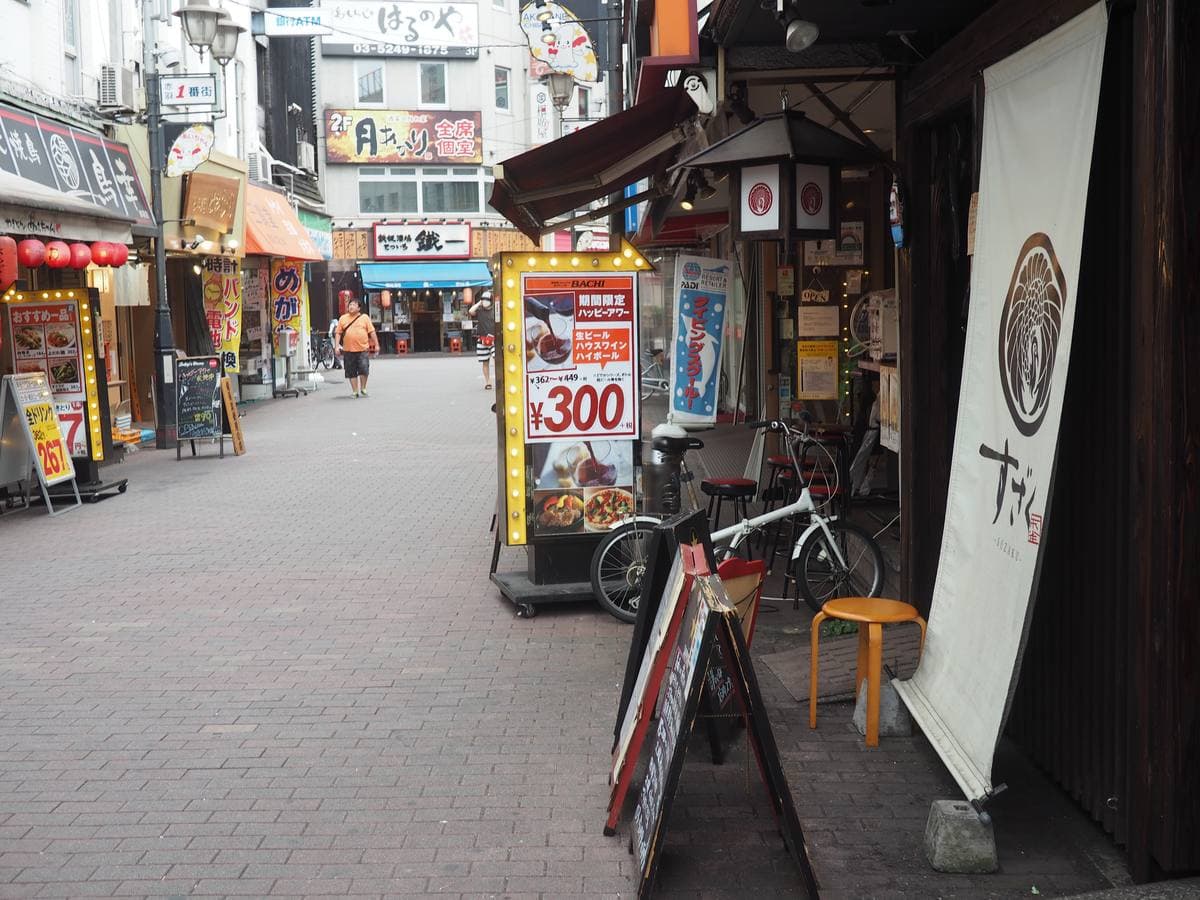 A narrow street of small shops and signs