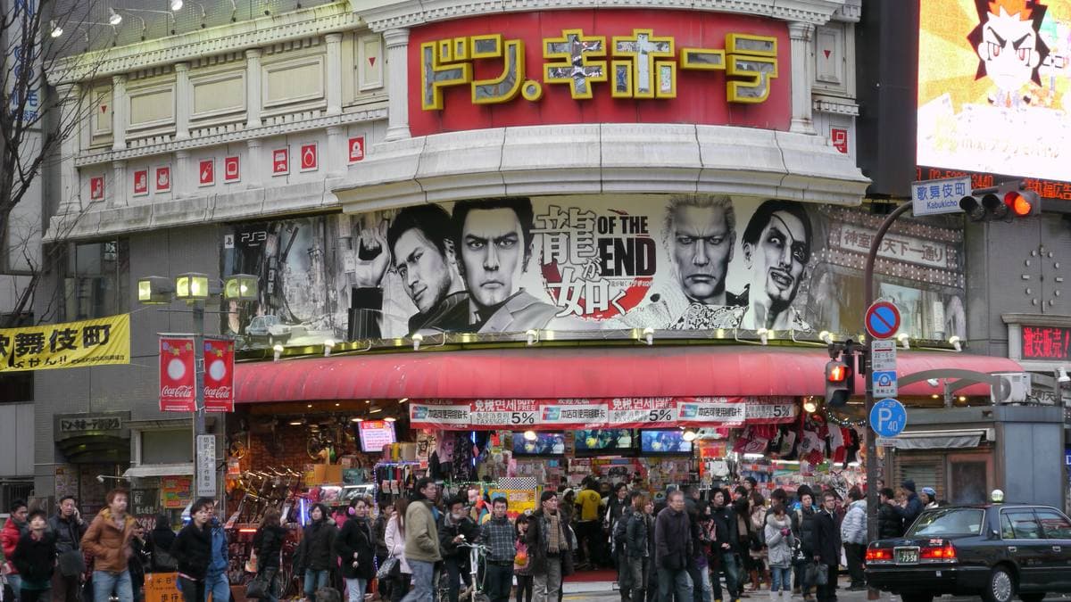 A shopfront covered in signs, crowds on the pavement