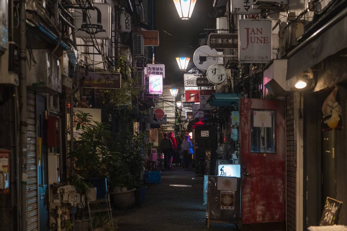 A narrow alley of tiny two-storey bars, lanterns and signs