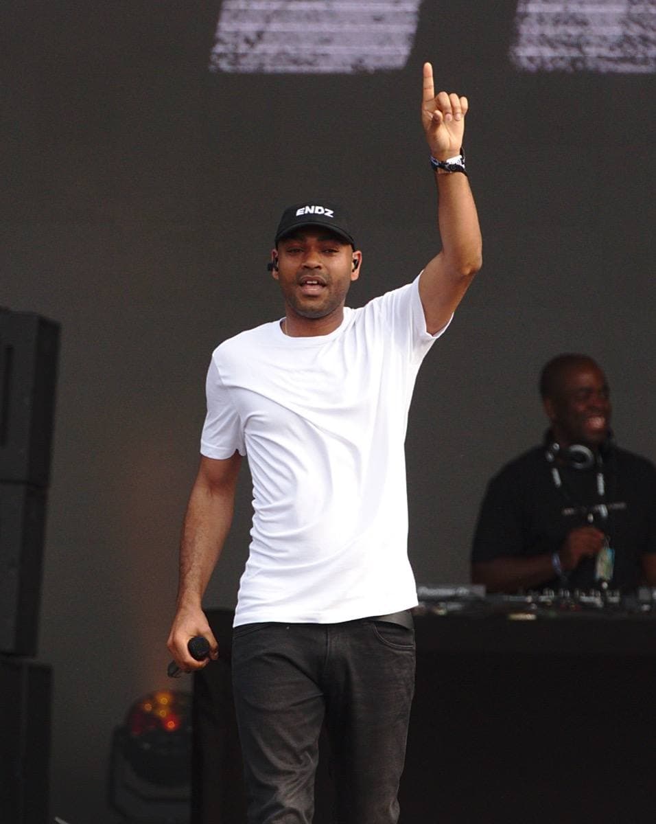 A rapper performing on stage with a microphone