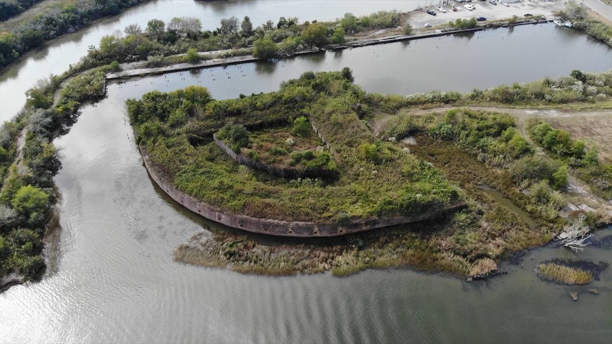 A ring-shaped overgrown fort on an island in the water of Chef Menteur Pass