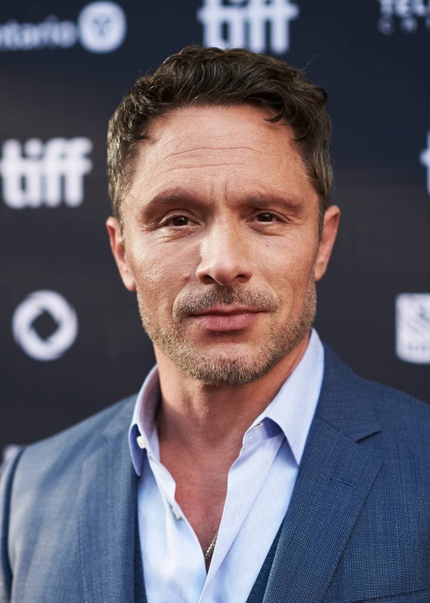 Nic Pizzolatto in a blue suit on a red carpet
