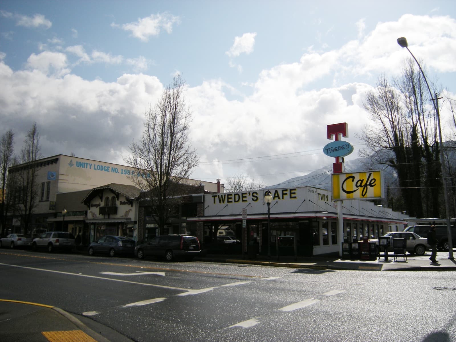 Twede’s Cafe exterior and sign, with cars and neighbouring buildings.