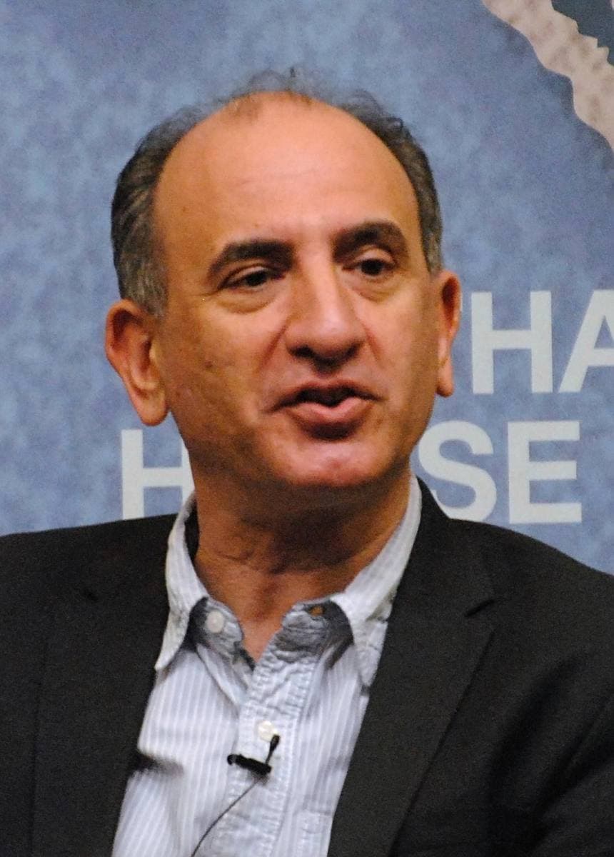 Armando Iannucci in a dark jacket and striped shirt, speaking
