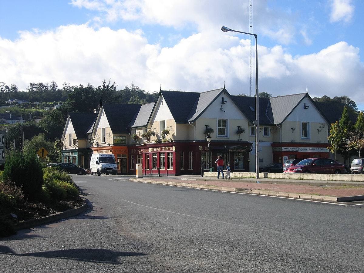 A village road with a row of gabled houses and shops