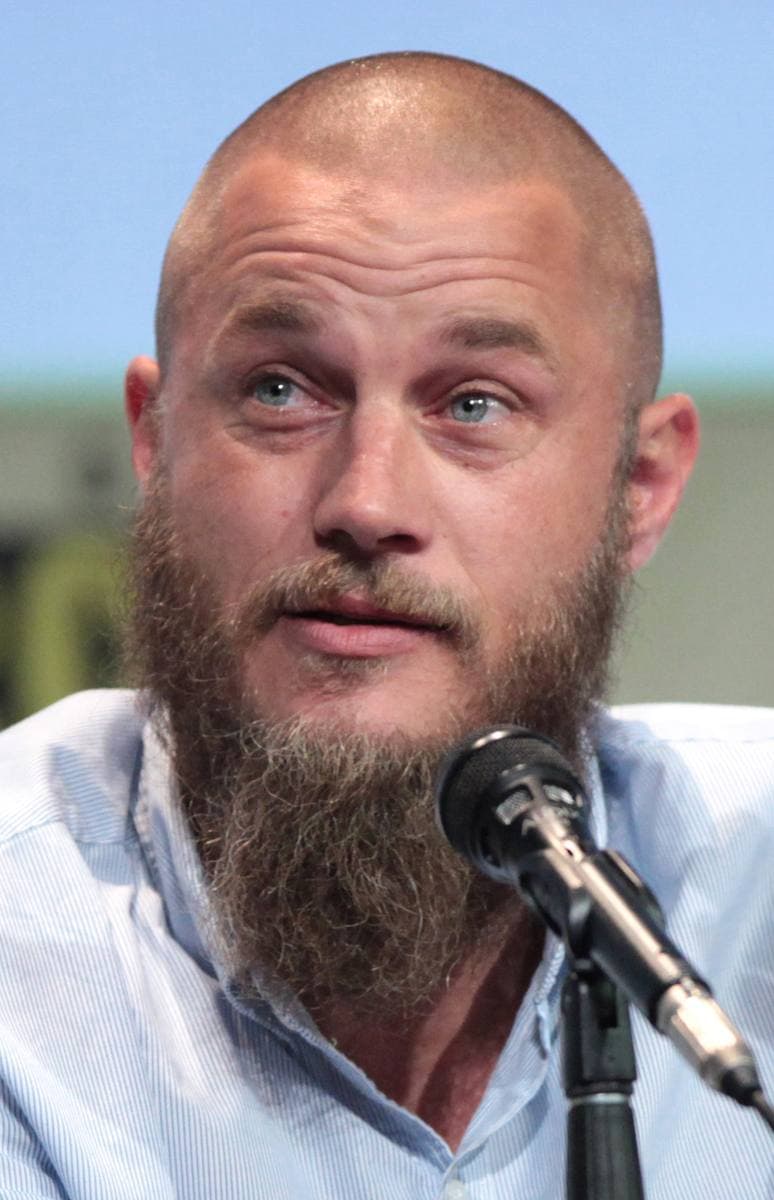 Travis Fimmel, bearded, speaking into a microphone