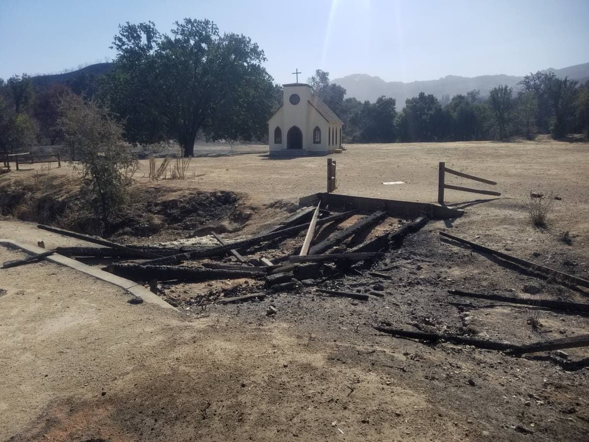 A small white chapel in a burnt field
