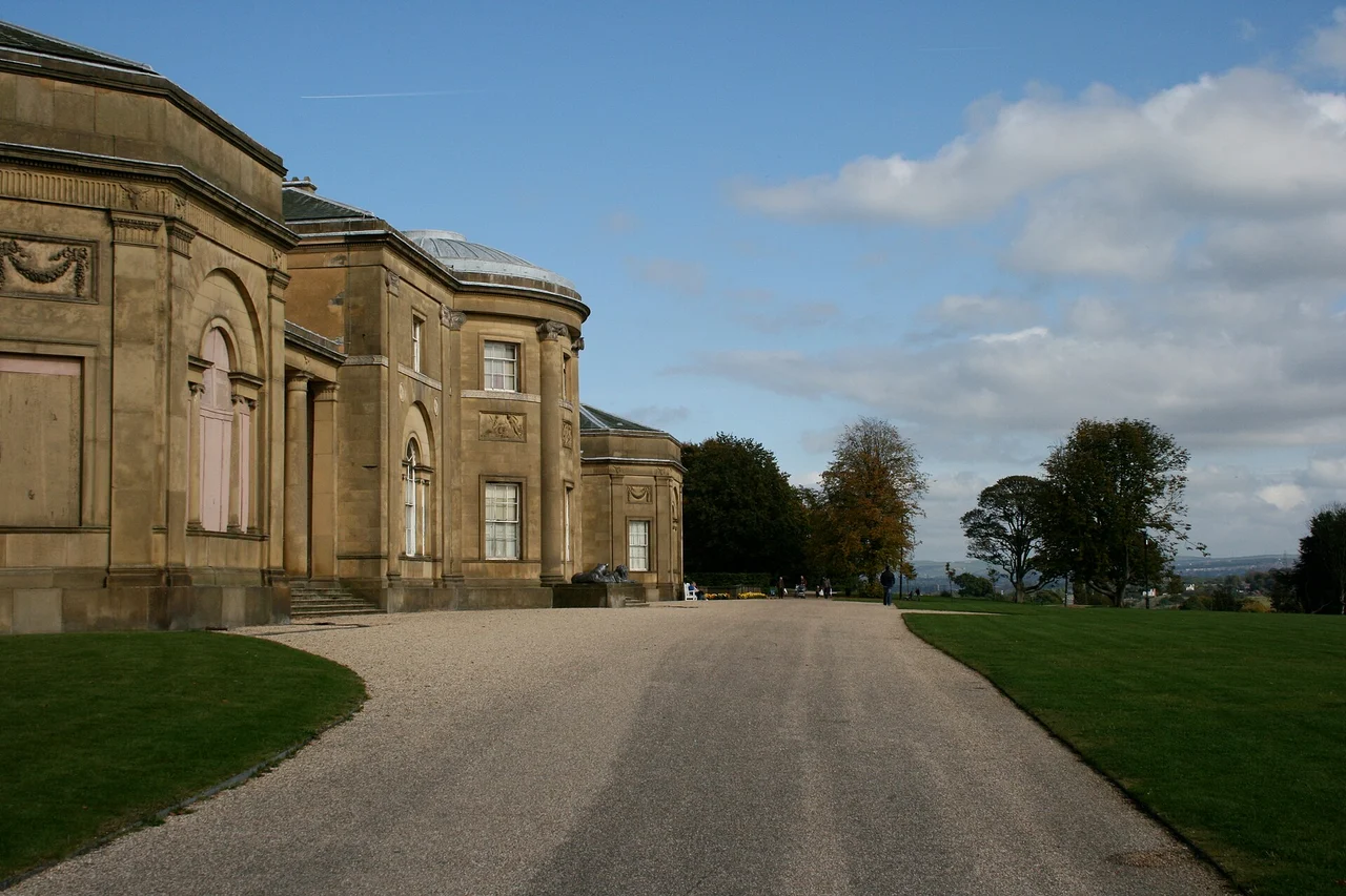 Historic stone façade of Heaton Hall beside a gravel approach and lawn