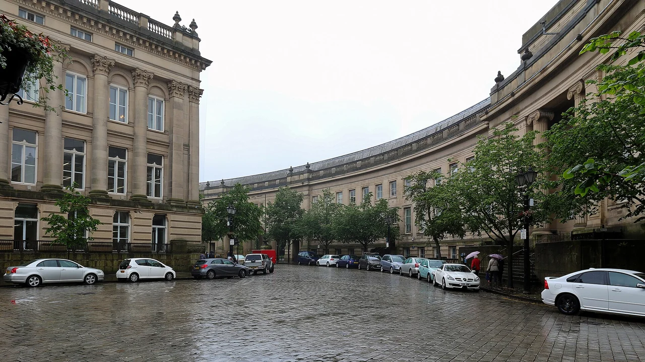 Curving stone façades of Le Mans Crescent in Bolton viewed across the cobbled street