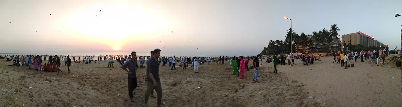 Wide view of people on Juhu beach at sunset